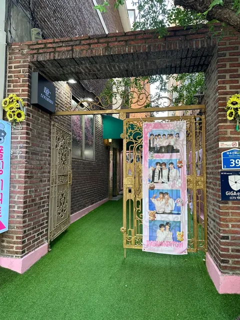 Brick archway with a gold gate and green artificial grass, building number 39